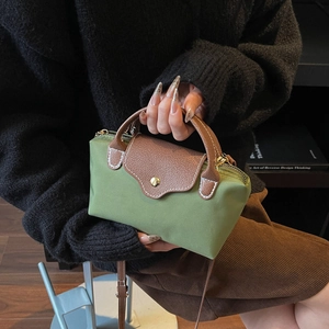Contrast color green nylon mini handbag with brown leather flap and golden snap closure