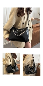 Détail d'un sac cabas noir brillant avec texture en cuir et bandoulière réglable