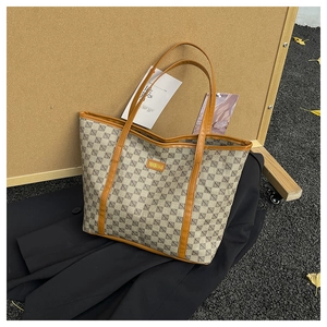 Detail of geometric pattern tote bag with leather handles and fashion logo label