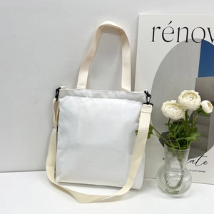 Detail of minimalist cream canvas tote bag with adjustable shoulder strap and hardware