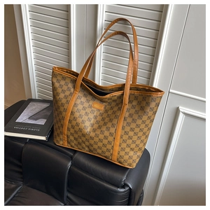 Close-up of brown tote bag with geometric pattern and brown leather straps on display