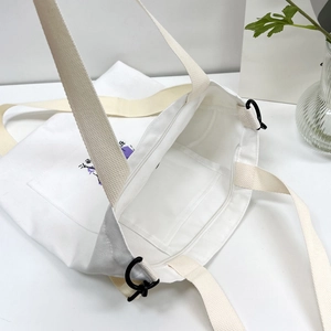 Top view of white canvas shoulder bag showing zipper closure and internal pocket structure