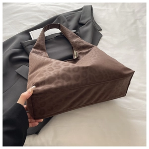 Detail of a leopard print tote bag in soft suede fabric with a spacious wide bottom design