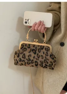 Detail of luxury leopard print faux fur handbag with ornate gold metal clasp and chain