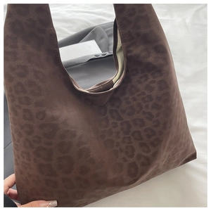 Detail showing deep brown leopard print tote bag with soft suede-like texture on fabric