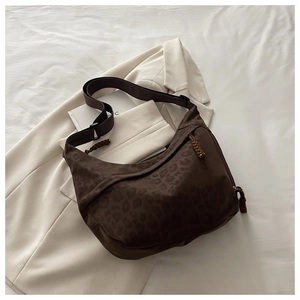 Detail of leopard print crossbody hobo bag with wide strap and woven cord zipper pull