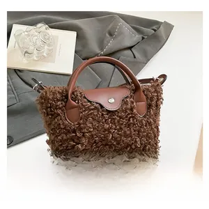 Detail of dark brown faux shearling bag texture with leather handle and metal button