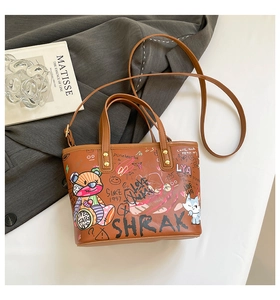 Détail d'un cabas en cuir marron avec graffiti street art et bandoulière amovible