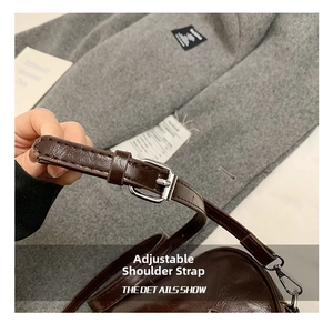 Détail de la bandoulière réglable en cuir marron avec boucle argentée du sac à main