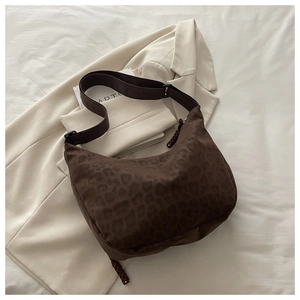 Detail of leopard print nylon hobo bag with adjustable wide shoulder strap on blazer