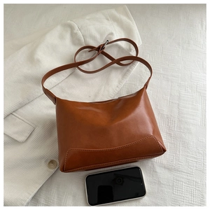 Detail of caramel faux leather bag showing soft matte texture and adjustable strap