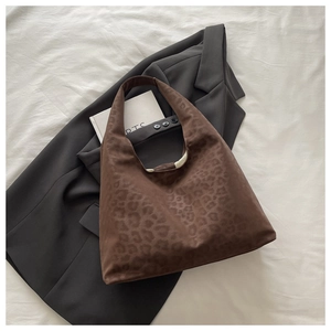 Detail view of large leopard print tote bag placed on a grey blazer for casual autumn style