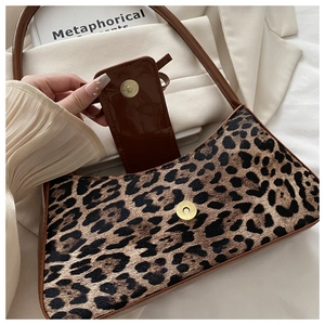 Close-up of leopard print baguette bag with brown faux leather flap and metal magnetic buckle