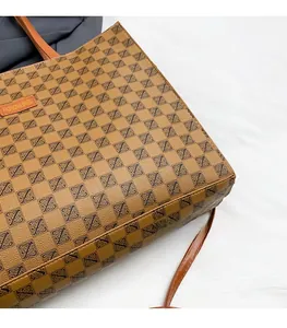 Detail of checkered tote bag with orange leather handles and embossed fashion label