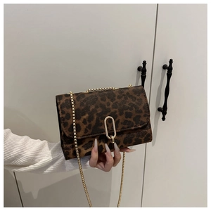 Detailed close-up of leopard print crossbody bag with gold U-shaped metal lock and chain