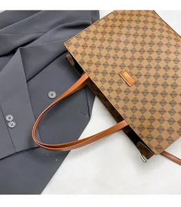 Detail of vintage tote bag with geometric print and orange leather label on grey blazer