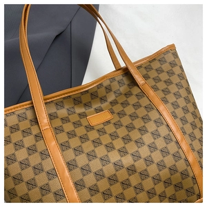 Detailed close-up of brown tote bag showing premium PU leather texture and geometric pattern