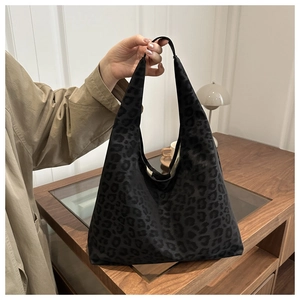 Detailed macro view of dark leopard print texture on a large matte canvas tote bag