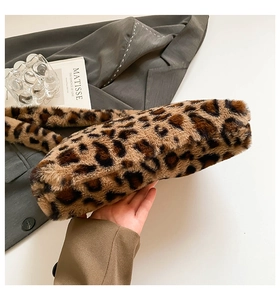 Detail showing the soft texture of the faux fur leopard print handbag held by hand
