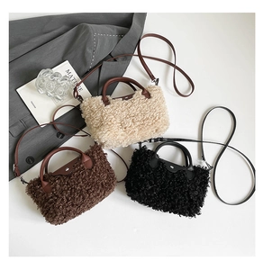 Close-up of plush mini crossbody bags in cream, brown, and black with leather details