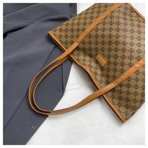 Detail of vintage tote bag featuring brown geometric pattern and leather brand tag