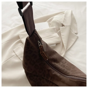 Close-up of leopard pattern dark texture crossbody bag with adjustable strap and zipper details