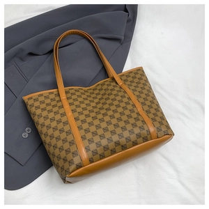 Detail of vintage geometric print tote bag featuring brown faux leather trim and handle