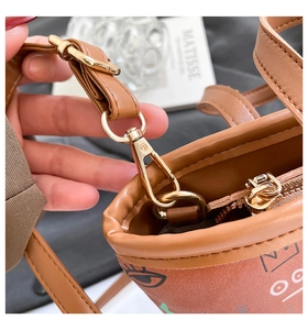 Détails du fermoir doré et de la bandoulière sur le sac à bandoulière marron imprimé