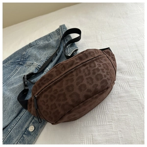Detail of leopard print crossbody bag with brown suede texture and black strap on denim