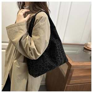 Detail of leopard print tote bag with soft suede texture on camel trench coat