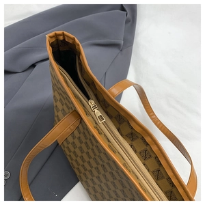 Macro view of golden metal zipper and internal compartment of brown printed tote bag