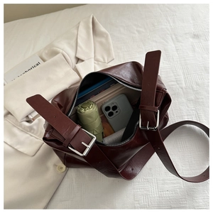 Intérieur spacieux d'un sac bordeaux avec téléphone, parapluie et livres pour capacité