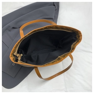 Detail view of large tote bag interior showing black lining and gold zipper closure