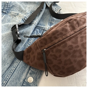 Detailed close-up of leopard print waist bag with black adjustable strap and buckle