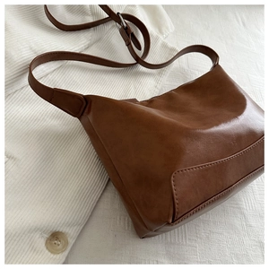 Detail of vintage brown shoulder bag with adjustable strap and matte faux leather texture