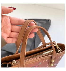Gros plan d'un sac cabas marron avec lettrage graffiti coloré et détails dorés
