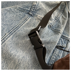 Detailed view of the leopard crossbody bag black plastic buckle and nylon strap