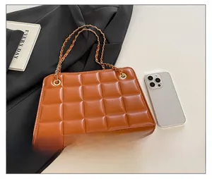 Detailed view of brown quilted chain bag with a smartphone showing internal storage capacity