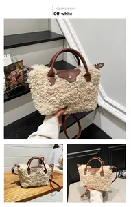 Detail of cream faux shearling tote bag with brown leather handles and silver buckle