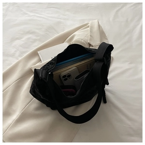 Top view of a black quilted crossbody bag showing large capacity for books and essentials
