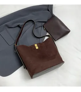 Détail du sac fourre-tout en daim marron foncé avec fermoir doré et pochette assortie