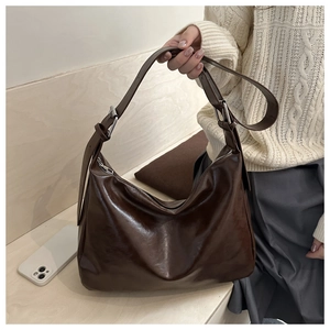 Détail du sac fourre-tout en cuir PU marron foncé brillant avec ferrures argentées