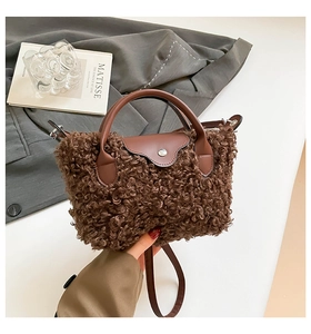 Detail of winter plush shoulder bag with curly lamb wool texture and leather handle