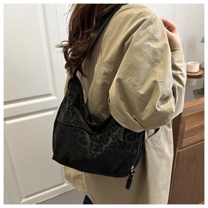 Close-up of black leopard print shoulder bag with metallic zipper and durable strap