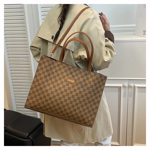 Detail of vintage tote bag featuring geometric print and dual straps on a model in a trench coat