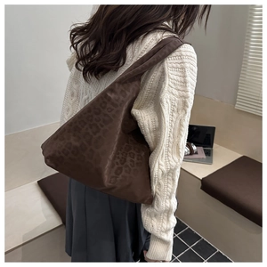 Detail of dark brown leopard print tote bag with stylish integrated knotted shoulder strap