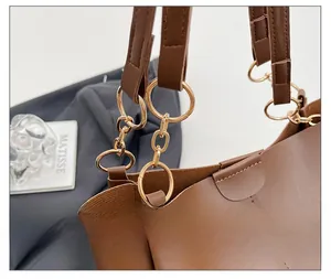 Close-up of premium gold hardware and leather stitching on a brown tote bag