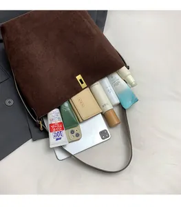 Détail montrant la grande capacité du sac cabas en daim marron avec objets du quotidien