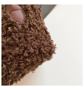 Close-up of soft brown teddy fur texture and premium leather handle on a shoulder bag