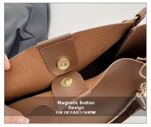 Detail of the golden magnetic closure and textured inner lining of a dark brown tote bag